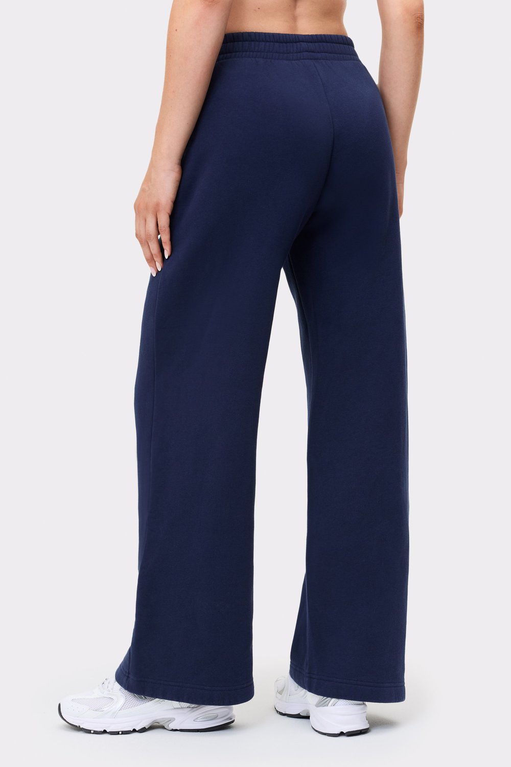 Rückansicht eines Models in den dunkelblauen Relaxed Wide Sweatpants von Stronger mit Oversize-Passform und geradem Bein.