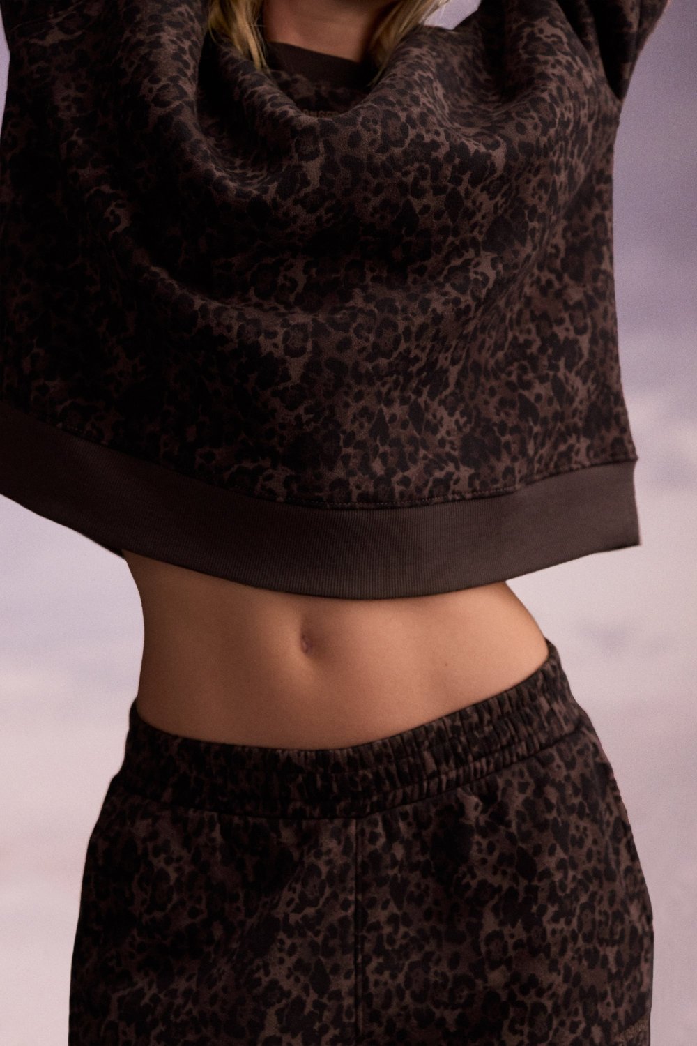 Close-up of a person wearing the Relaxed Sweatshirt in Dark Leo from stronger, showing the ribbed hem.