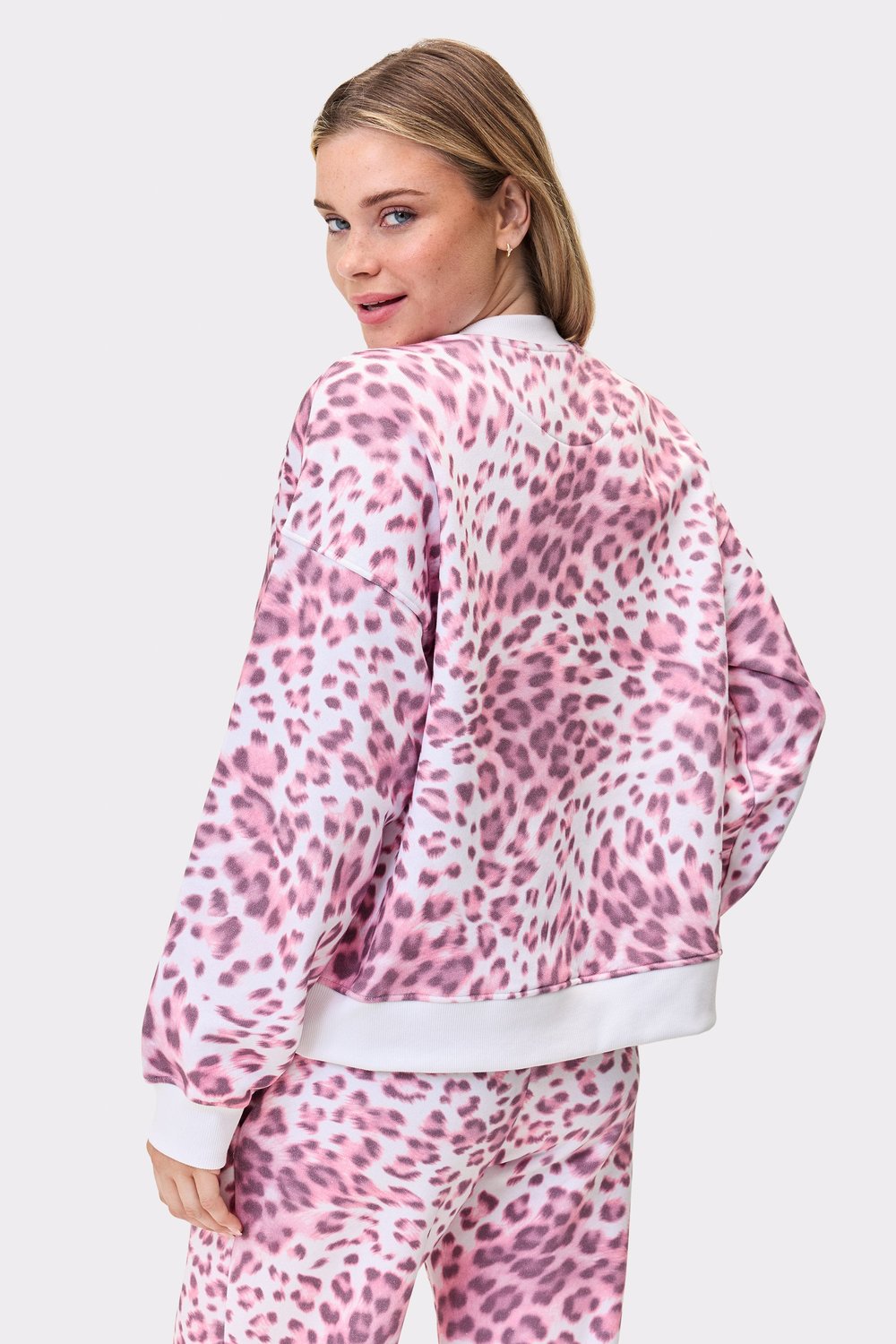 Back view of a model wearing the Relaxed Sweatshirt in pink leopard print by stronger, highlighting the oversized fit.