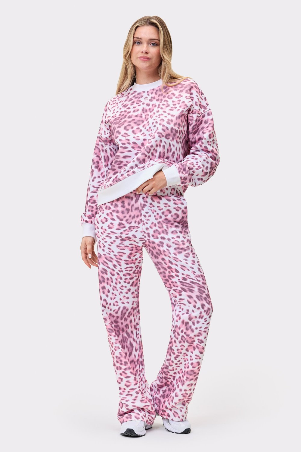 Model wearing the pink leopard print Relaxed Sweatshirt and matching sweatpants from Stronger, featuring an oversized fit.
