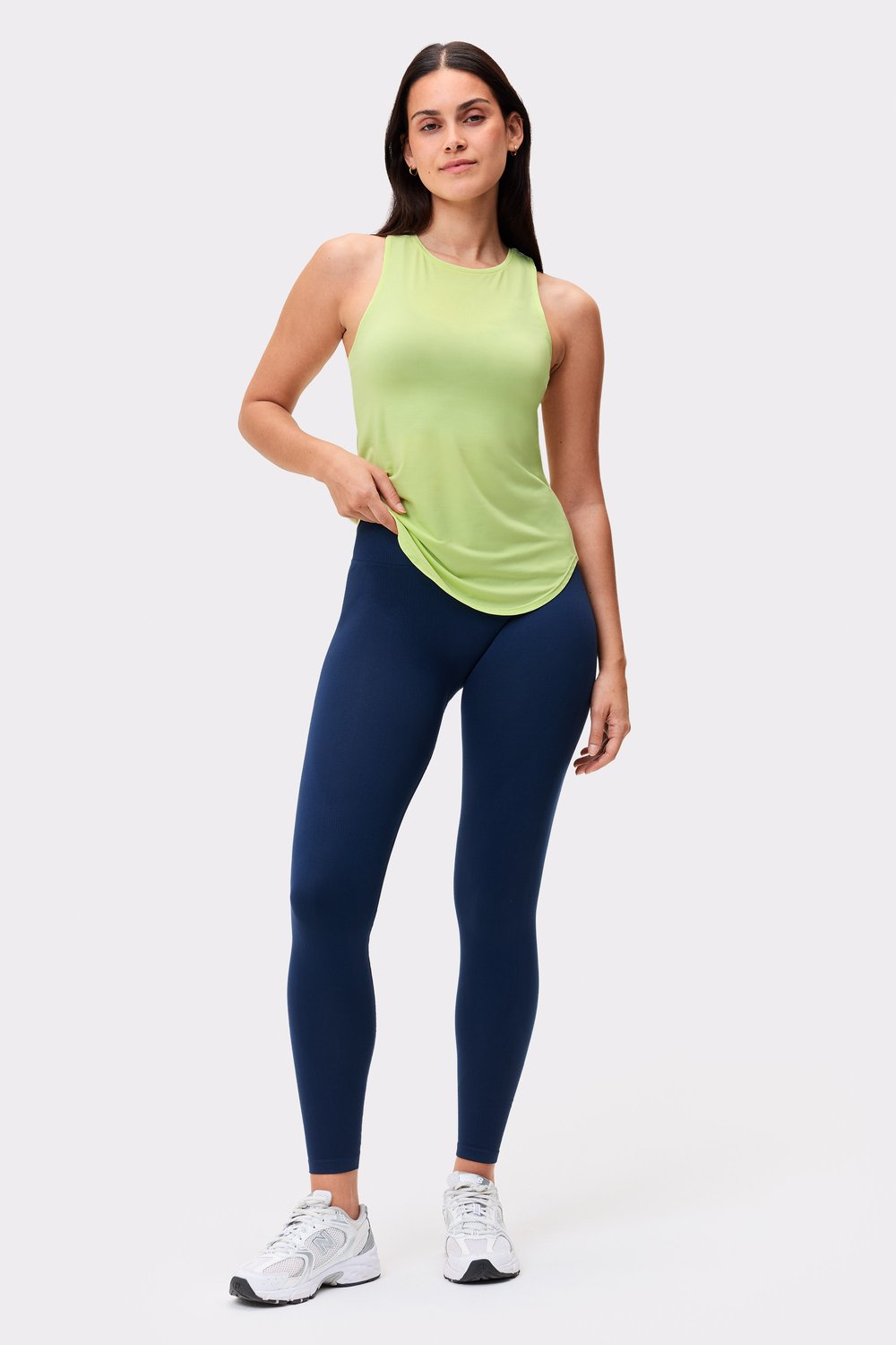 Model trägt das limettengrüne Airy Racerback Tank von Stronger mit lockerer Passform fürs Workout.