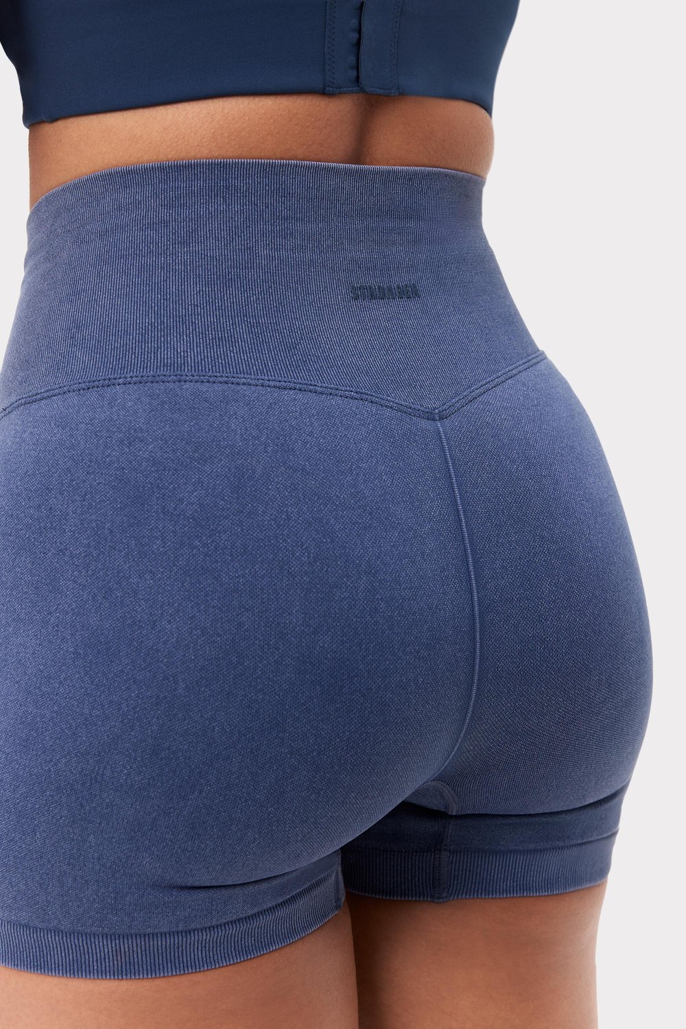 Achteraanzicht van de navy Washed Seamless Shorts van Stronger met een hoge geribbelde tailleband en gewassen look.