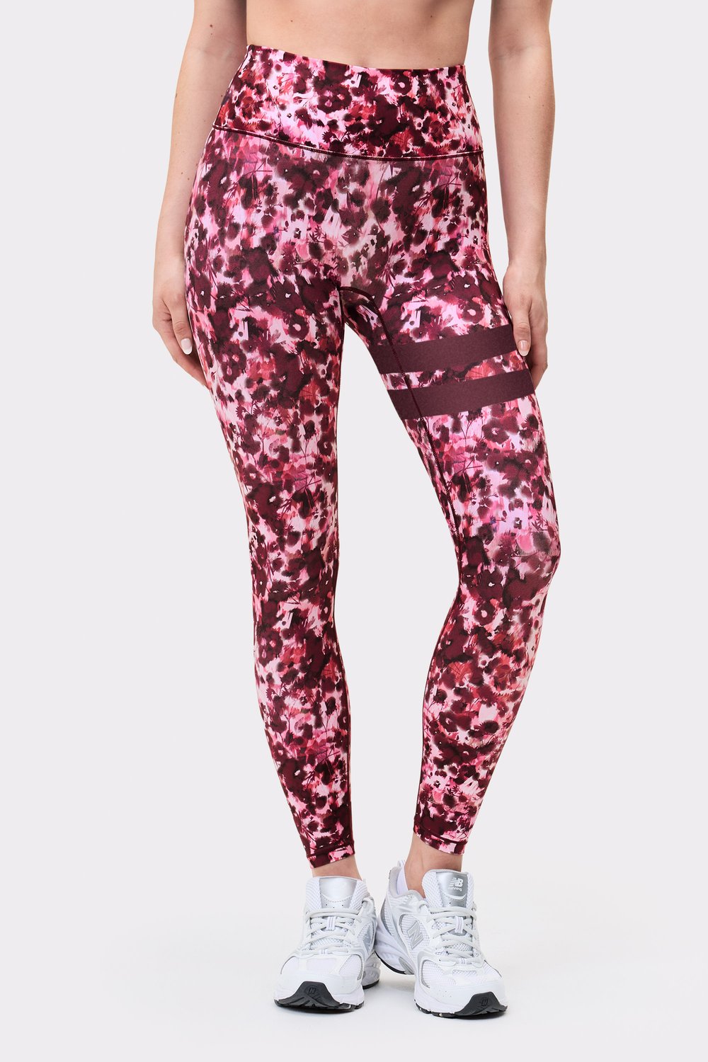 Front view of a model wearing Stronger The Signature One Leggings in Autumn Petals with signature stripes on the left leg.