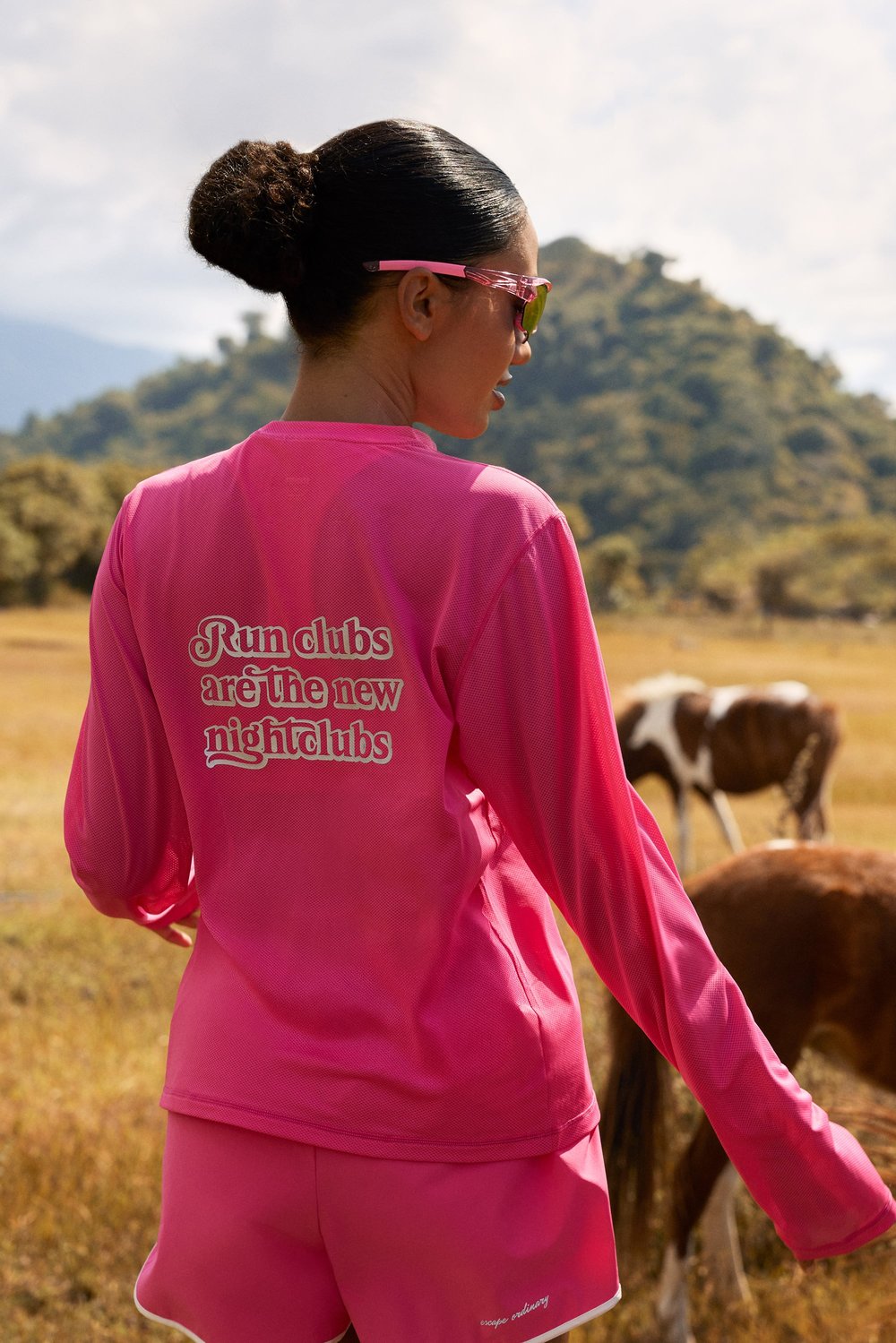 Pink Mesh Running Long Sleeve by Stronger featuring a reflective back graphic and breathable mesh in an outdoor setting.