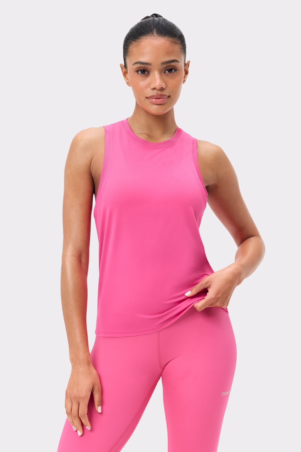 Front view of Stronger's pink Relaxed Tank, a quick-drying sleeveless top with a ribbed neckline and regular fit.