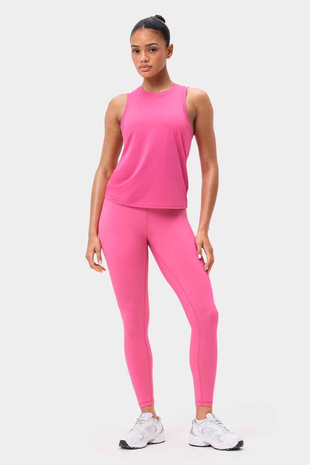 Front view of the dark pink Stronger Relaxed Tank, a breathable sleeveless top paired with matching leggings.