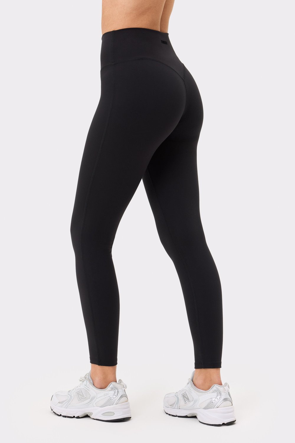 Back and side view of a woman wearing Stronger's black Soft Leggings, showing off the flattering high-waisted fit.