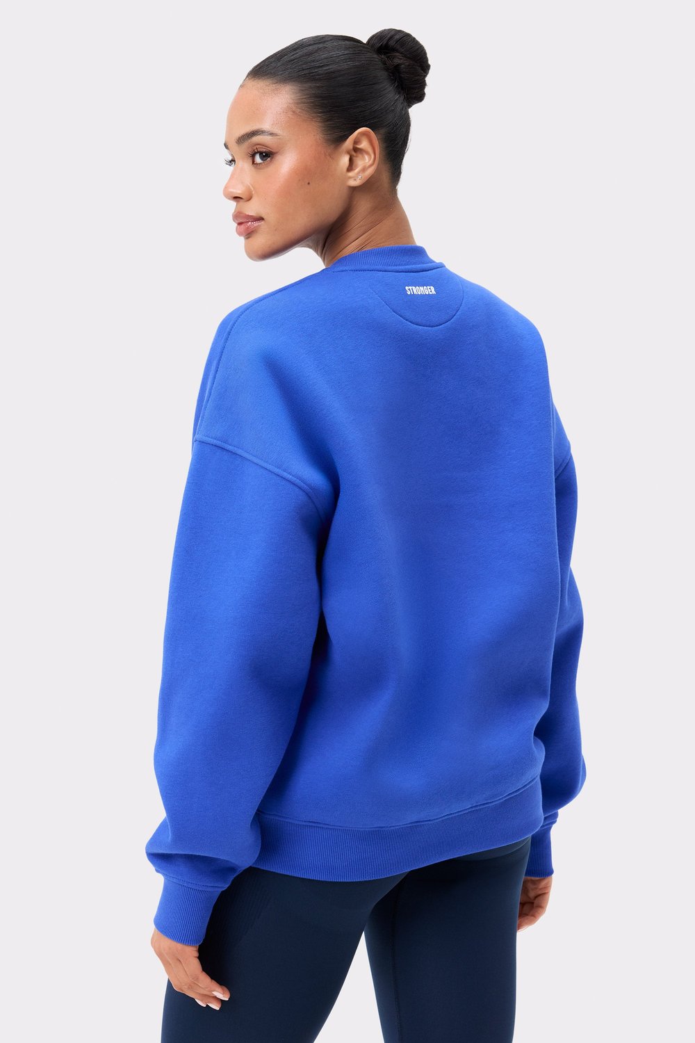 Model in Stronger blauen Comfy Sweatshirt, die die Oversized-Passform, lange Ärmel und die gebürstete Innenseite präsentiert.