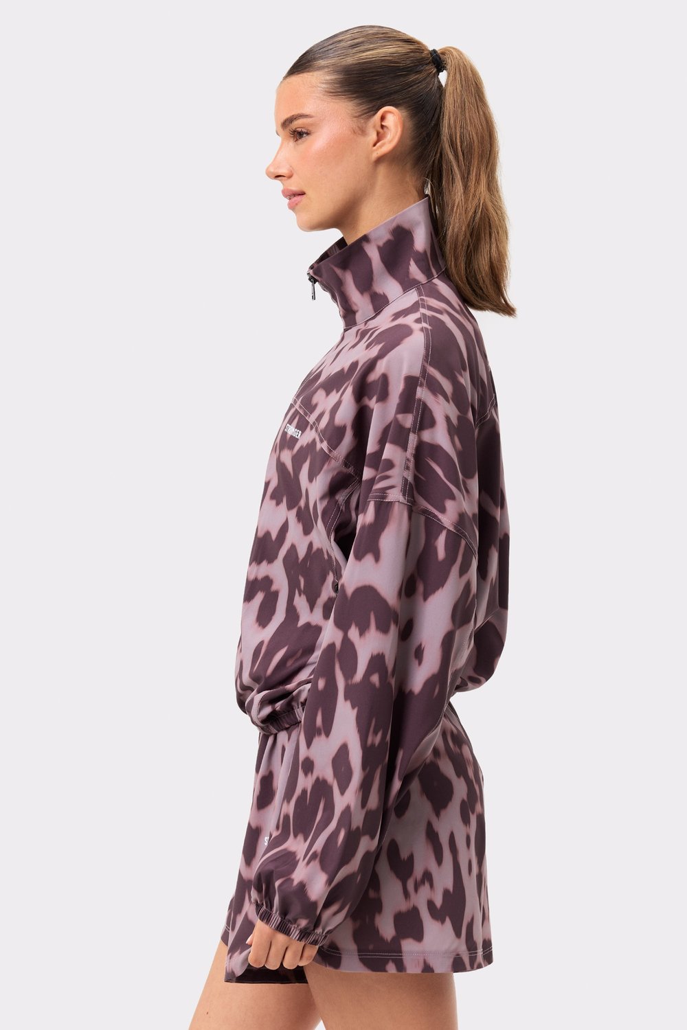 Zij-aanzicht van de Breezy Woven Jacket van Stronger in Leo Rush print, met lichtbruine luipaardprint en hoge kraag.