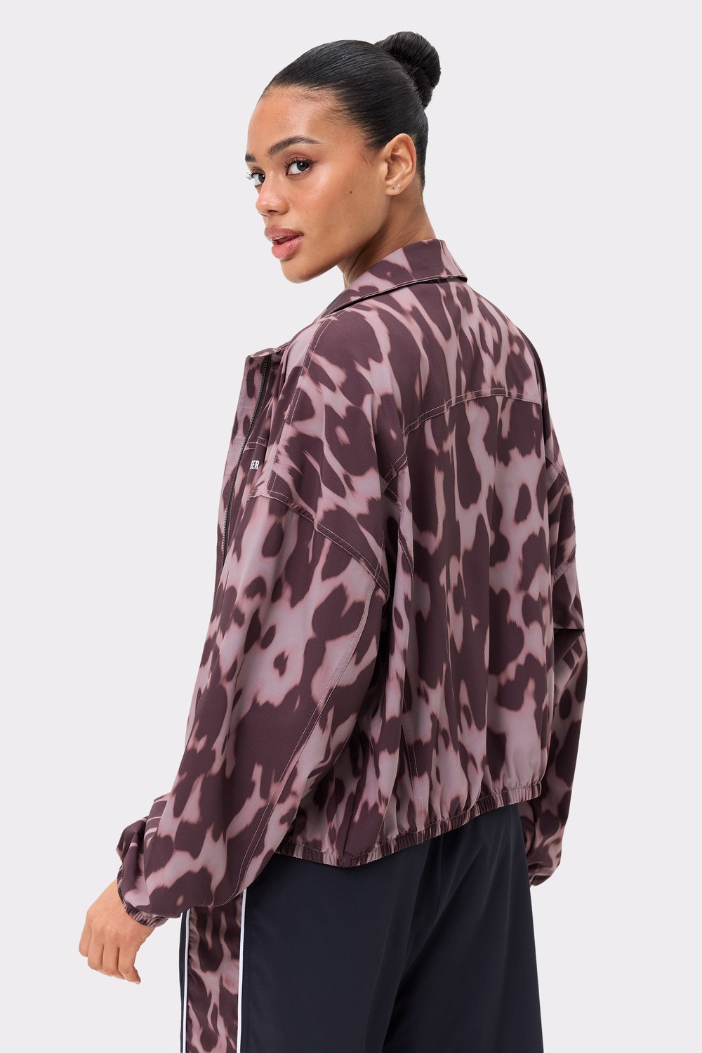 Zijaanzicht van de Breezy Woven Jacket van Stronger in Leo Rush-print, met een losse pasvorm en geweven stof met patroon.