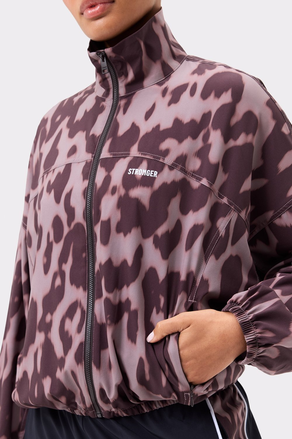 Close-up van de Stronger Breezy Woven Jacket in Leo Rush print, met een ritssluiting en stof met luipaardprint.