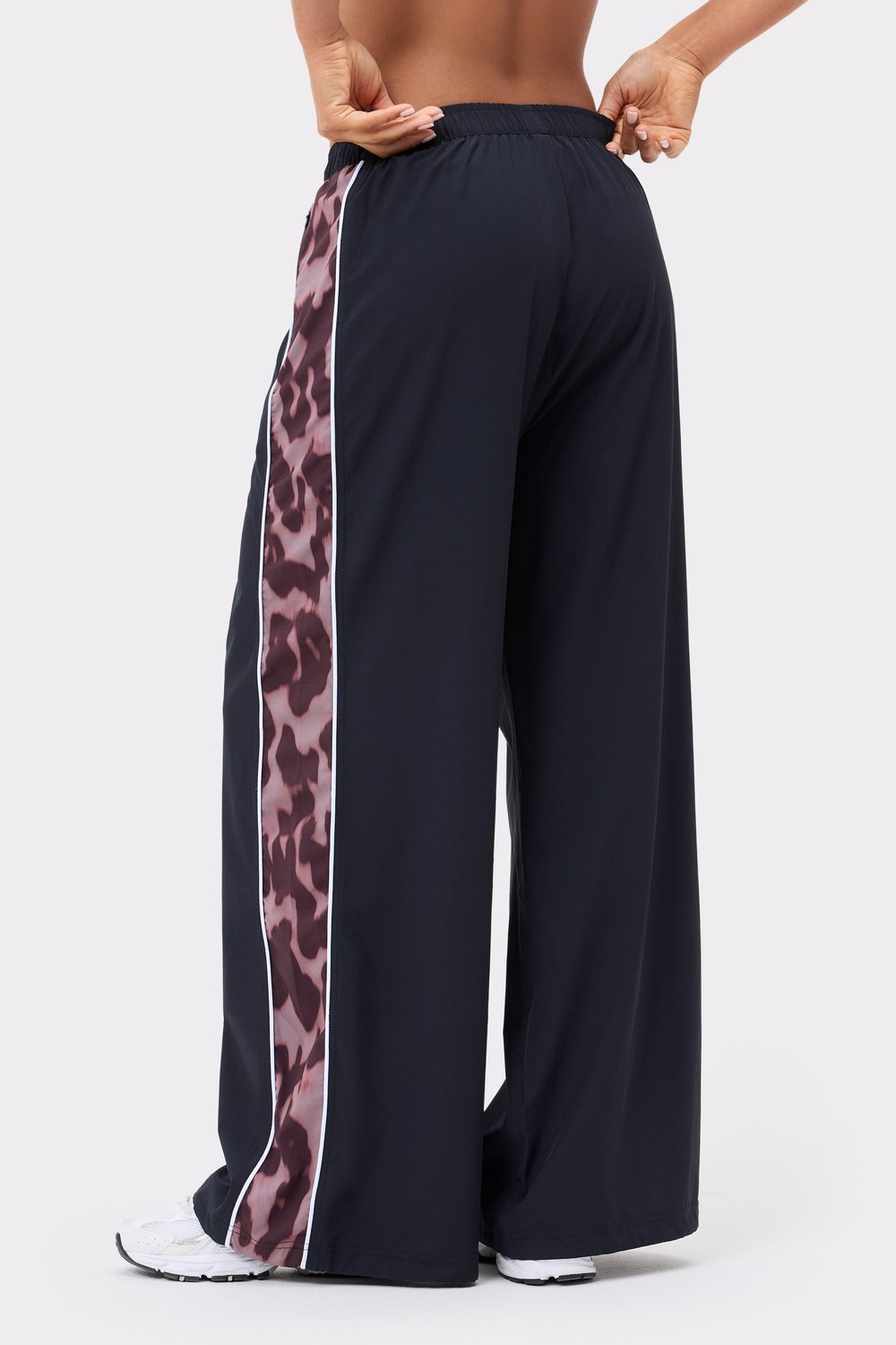 Zwarte Breezy Woven Pants van Stronger met een zijstreep in luipaardprint, witte bies en een losse, wijde pasvorm.