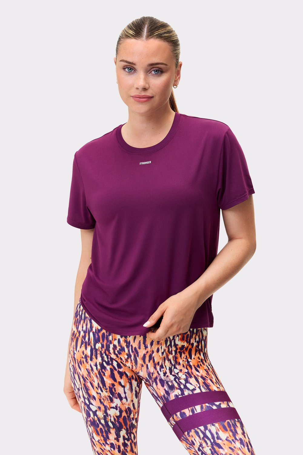 Front view of a model wearing the relaxed-fit Stronger tee in aubergine purple, showcasing the breathable active fabric.