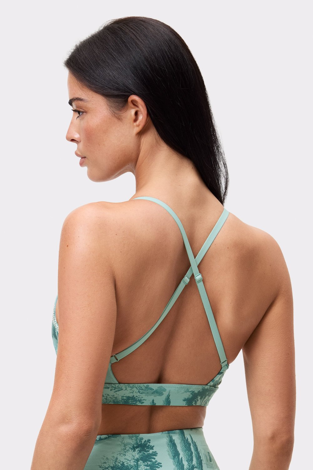 Nahaufnahme der verstellbaren, gekreuzten Träger am Rücken des hellblauen Signature Printed Strap Sports Bra.