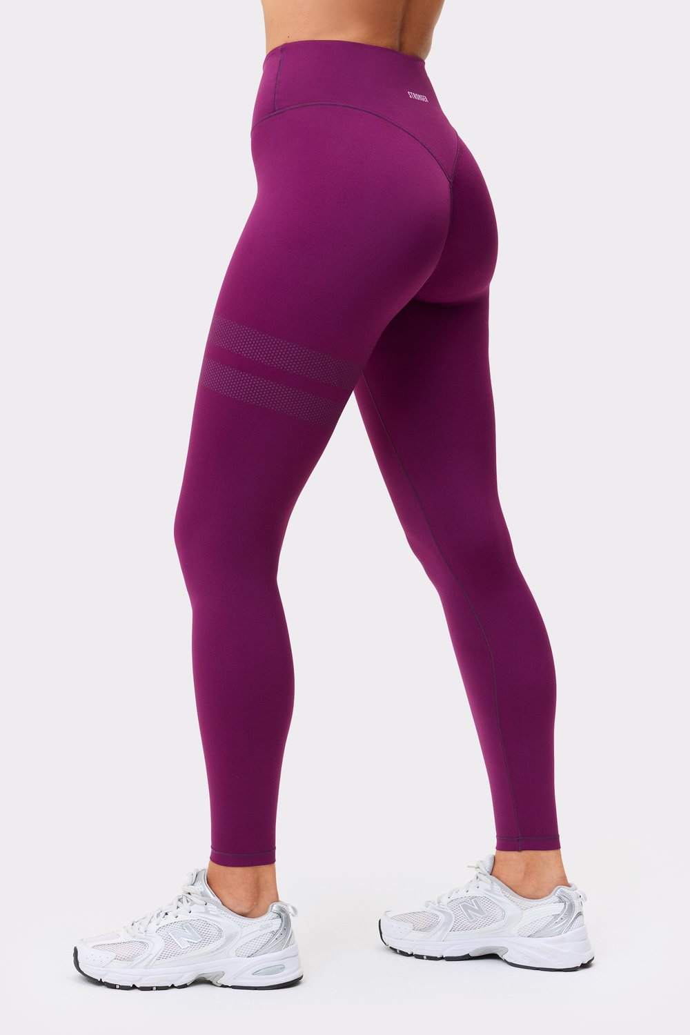 Back view of stronger leggings in aubergine purple, highlighting the signature lines on the leg.