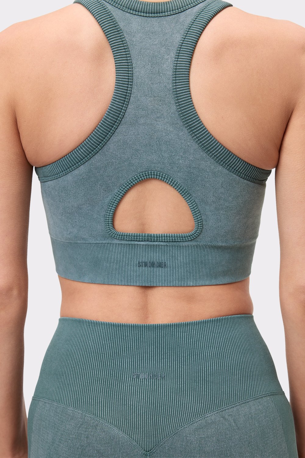 Nahaufnahme der Rückseite des Stronger Washed Seamless High Neck Bra in Silver Pine, die den Schlüssellochausschnitt zeigt.