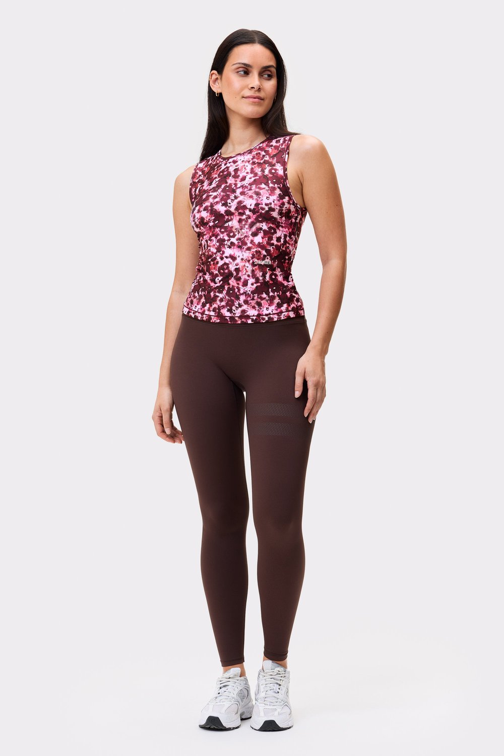 Front view of a model wearing the Signature Slim Tank Top in Autumn Petals from stronger, paired with leggings.