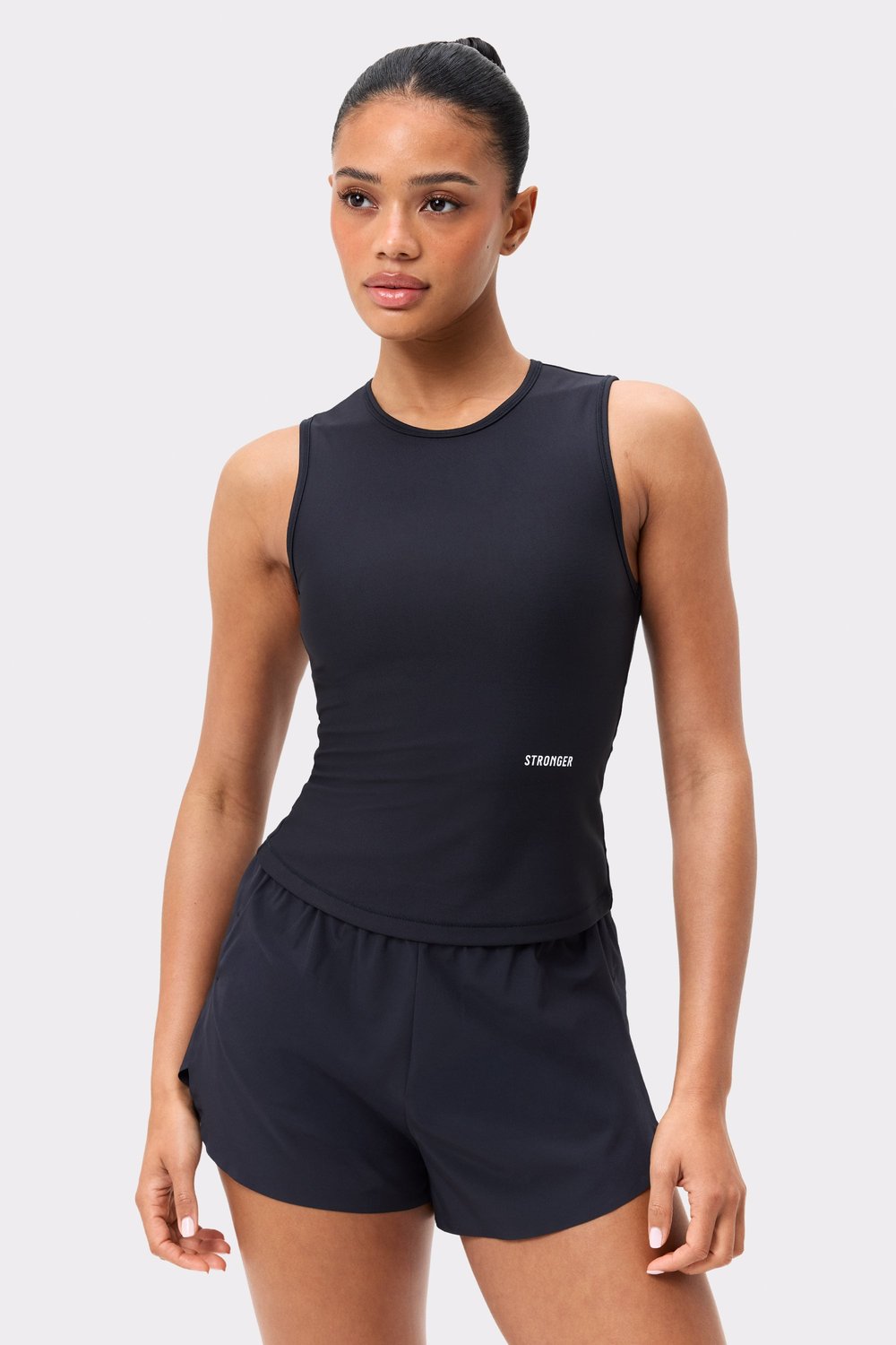 Front view of the black Signature Slim Tank Top by Stronger, featuring a slim fit, high neckline, and side logo.