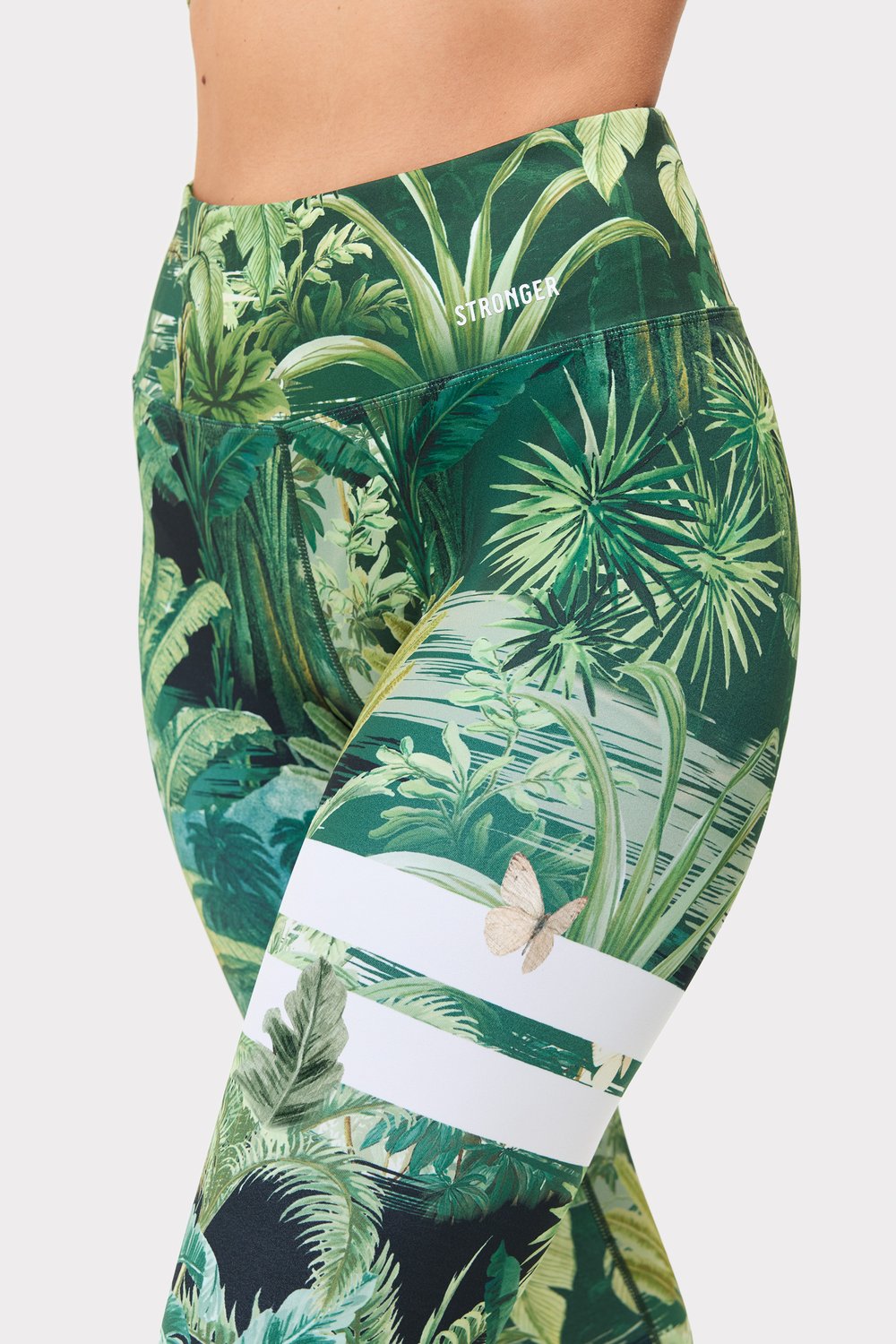 Nahaufnahme der Stronger Explore Printed Leggings mit Tropical Leaves Print, die hohe Taille und das Bund-Branding zeigen.