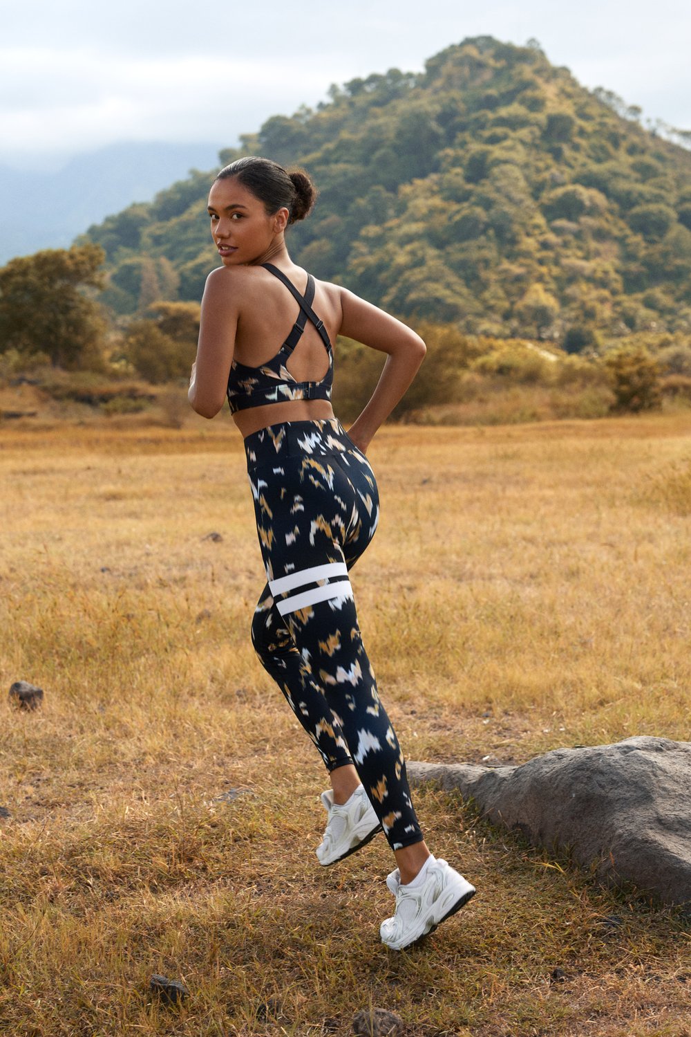 Model running in Stronger's high-waisted Explore Printed Leggings in Savannah Print, featuring signature white stripes.