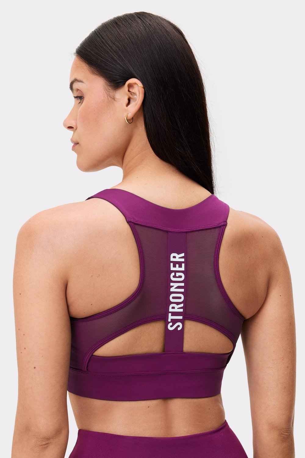 Back view of a model wearing the aubergine purple Bounce Sports Bra from stronger, featuring a mesh back and logotype.