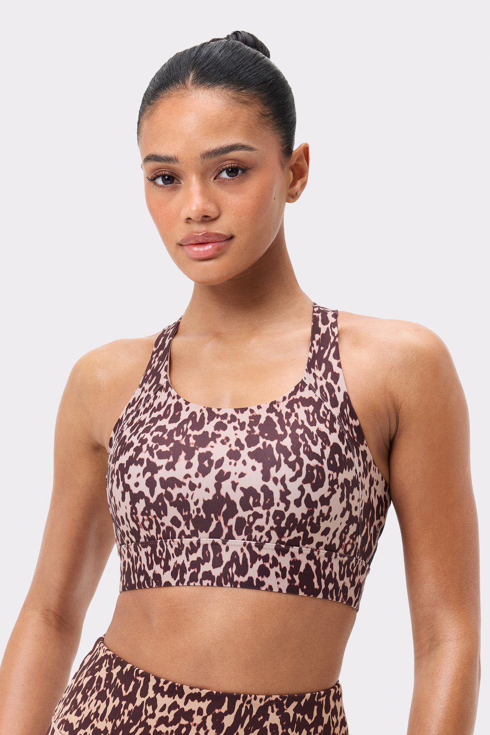 Front view of the Stronger Bounce Sports Bra in light brown Leo Rush print, featuring wide straps and high support.