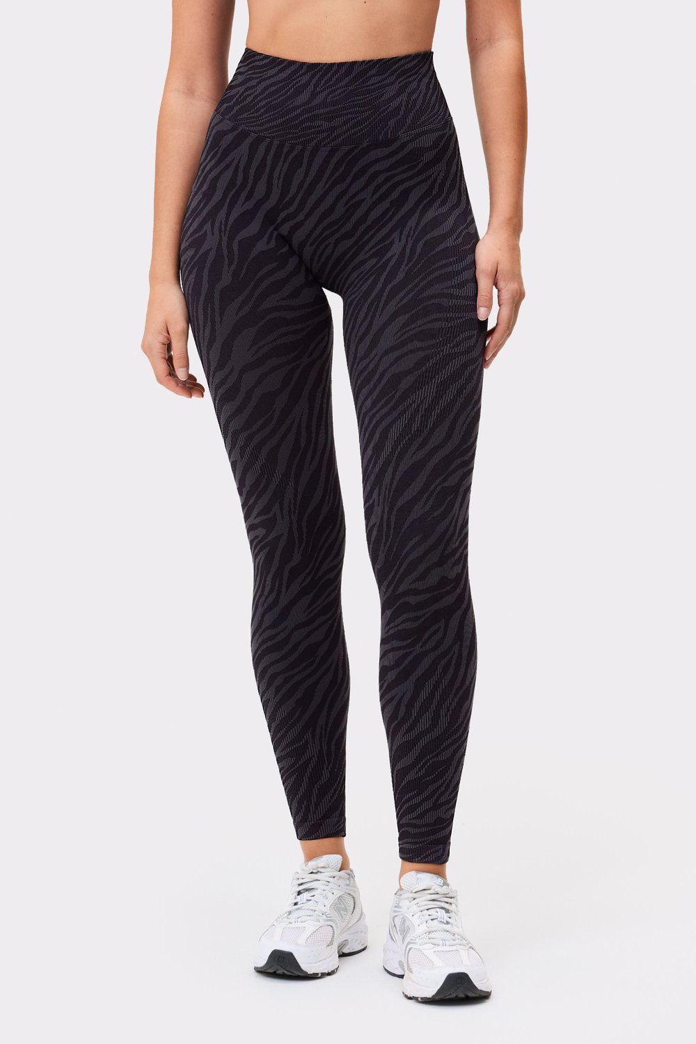 Model trägt die Seamless Contour Jacquard Leggings in Black Zebra von Stronger mit hoher Taille und strukturiertem Muster.
