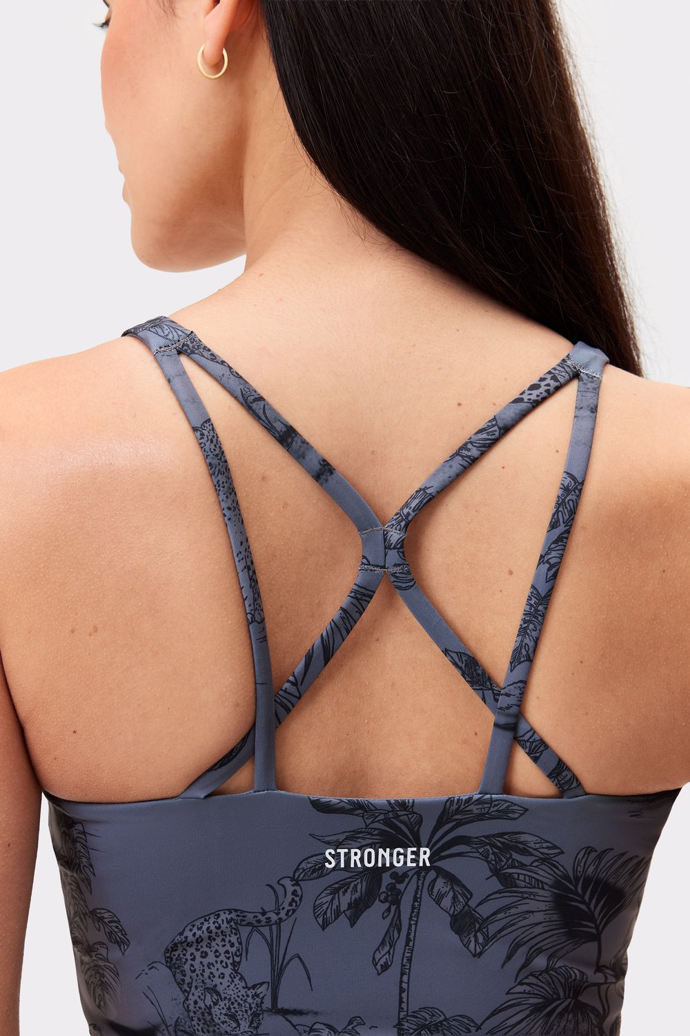 Person im Signature Strappy Tank von Stronger im Dark Toile-Print mit den filigranen Trägerdetails am Rücken.