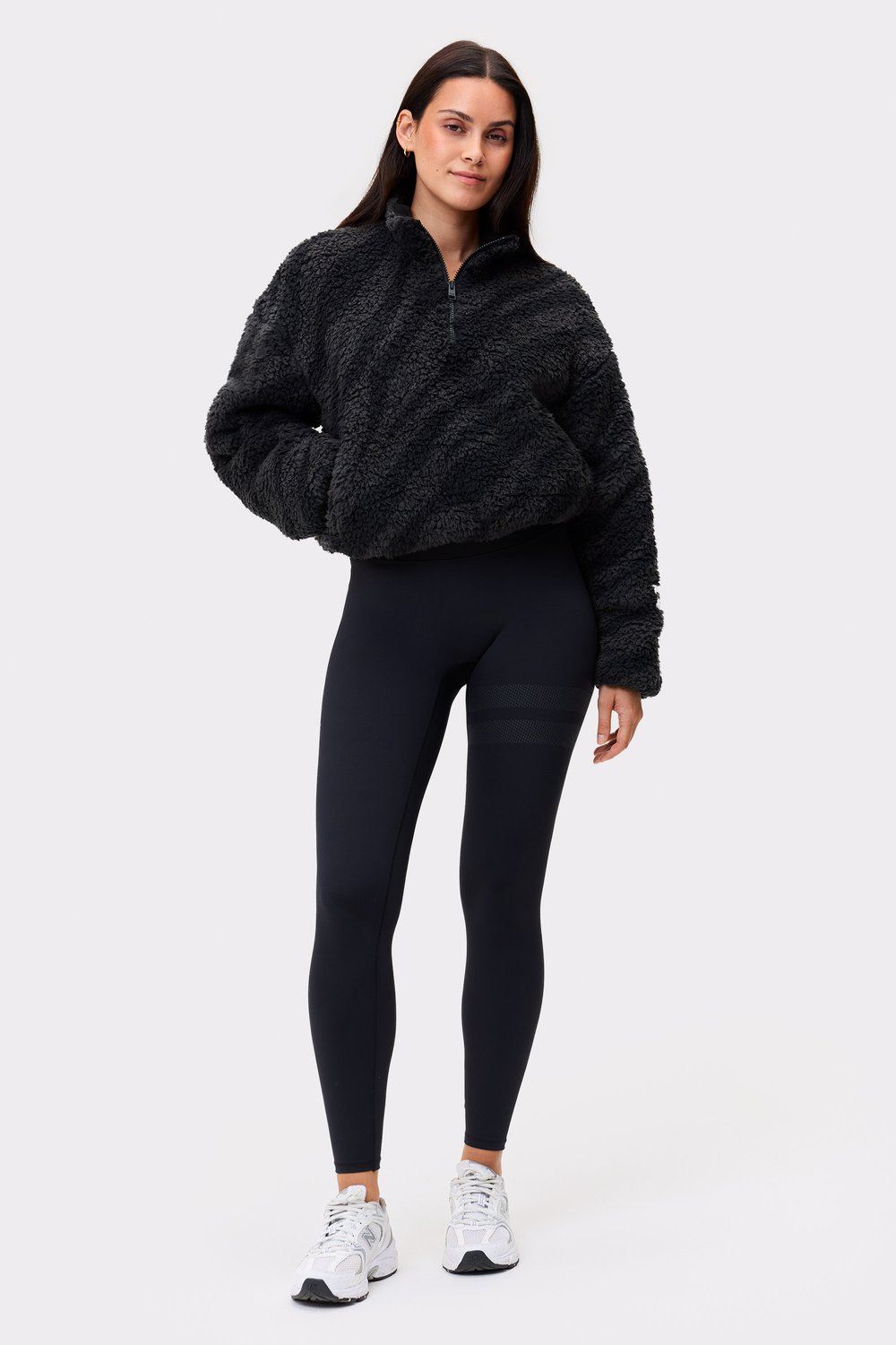 Model im schwarzen Zebra Pile Half Zip von Stronger, einer kuscheligen Fleece-Schicht mit Half-Zip und hohem Kragen.
