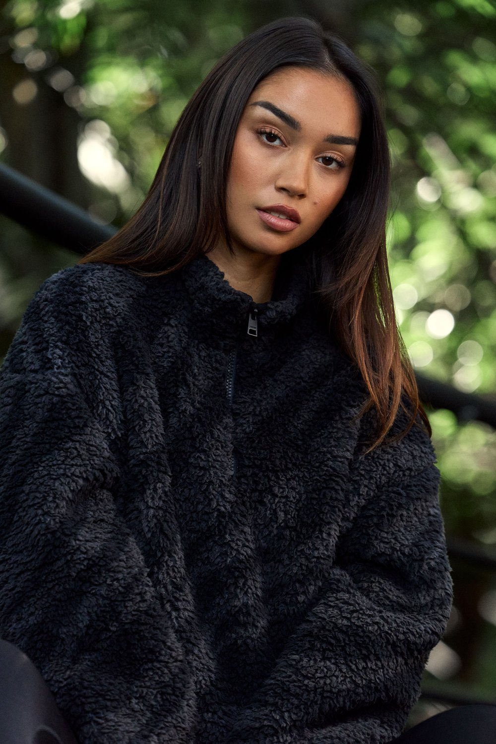 Model trägt die schwarze Pile Half Zip Jacket von Stronger aus gemütlichem Fleecematerial mit hohem Kragen.