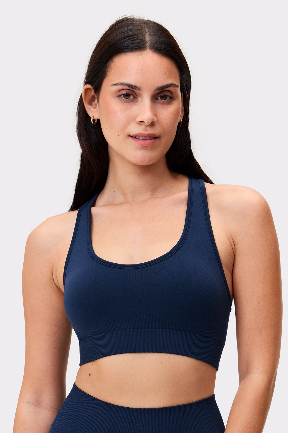 Model trägt den dunkelblauen Seamless Contour Sports Bra von Stronger mit einem unterstützenden und atmungsaktiven Design.