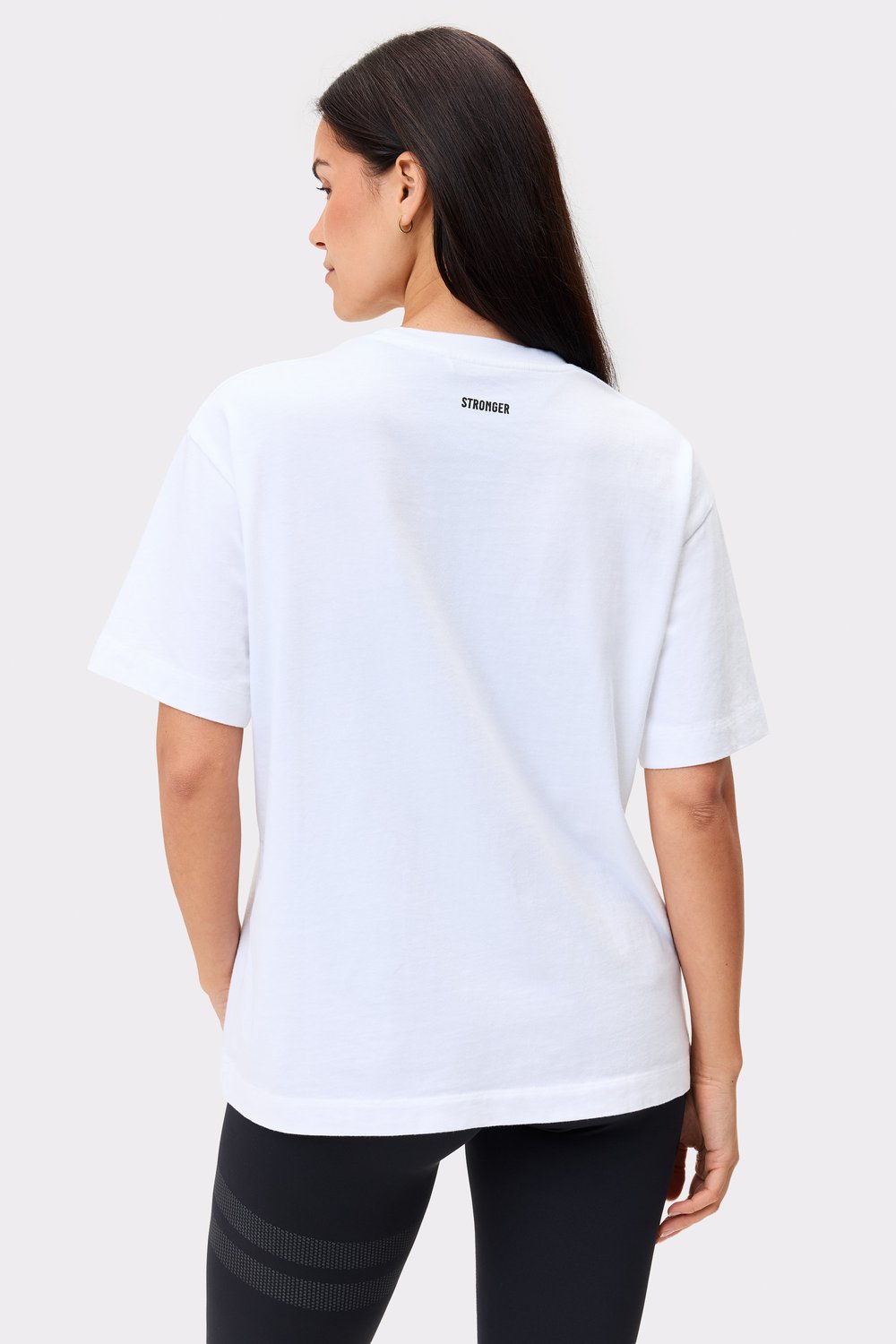 Rückansicht eines Models im weißen Essential T-shirt von Stronger mit normaler Passform und Bio-Baumwolle.