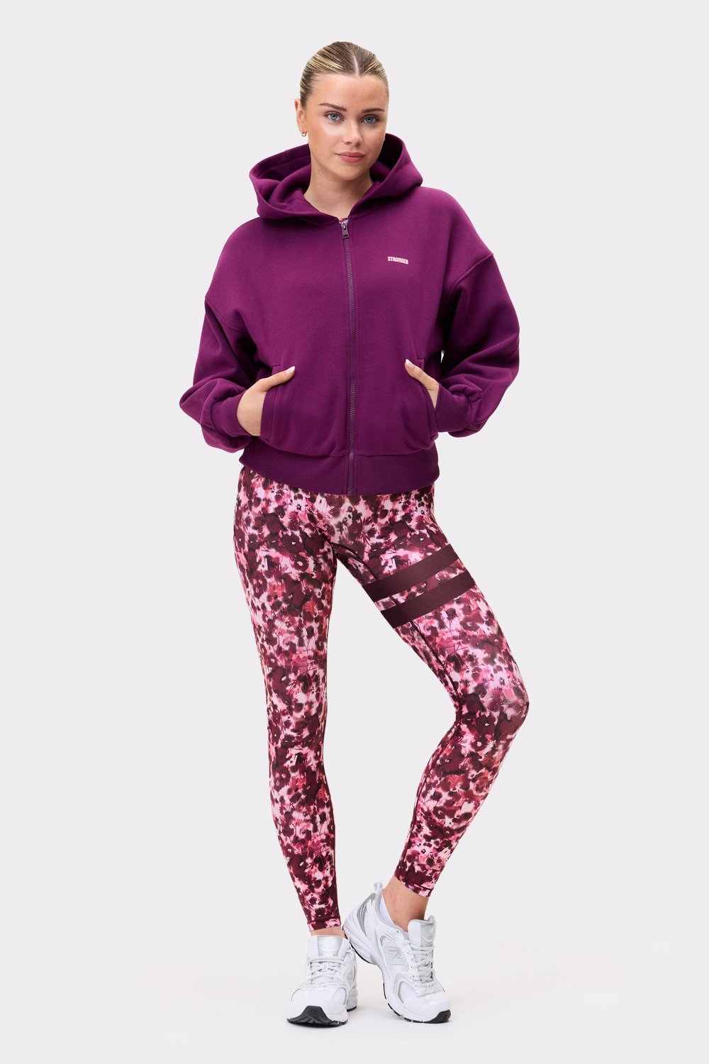 Model wearing the aubergine purple Relaxed Full Zip Hoodie from stronger, showing the full front zip and relaxed fit.