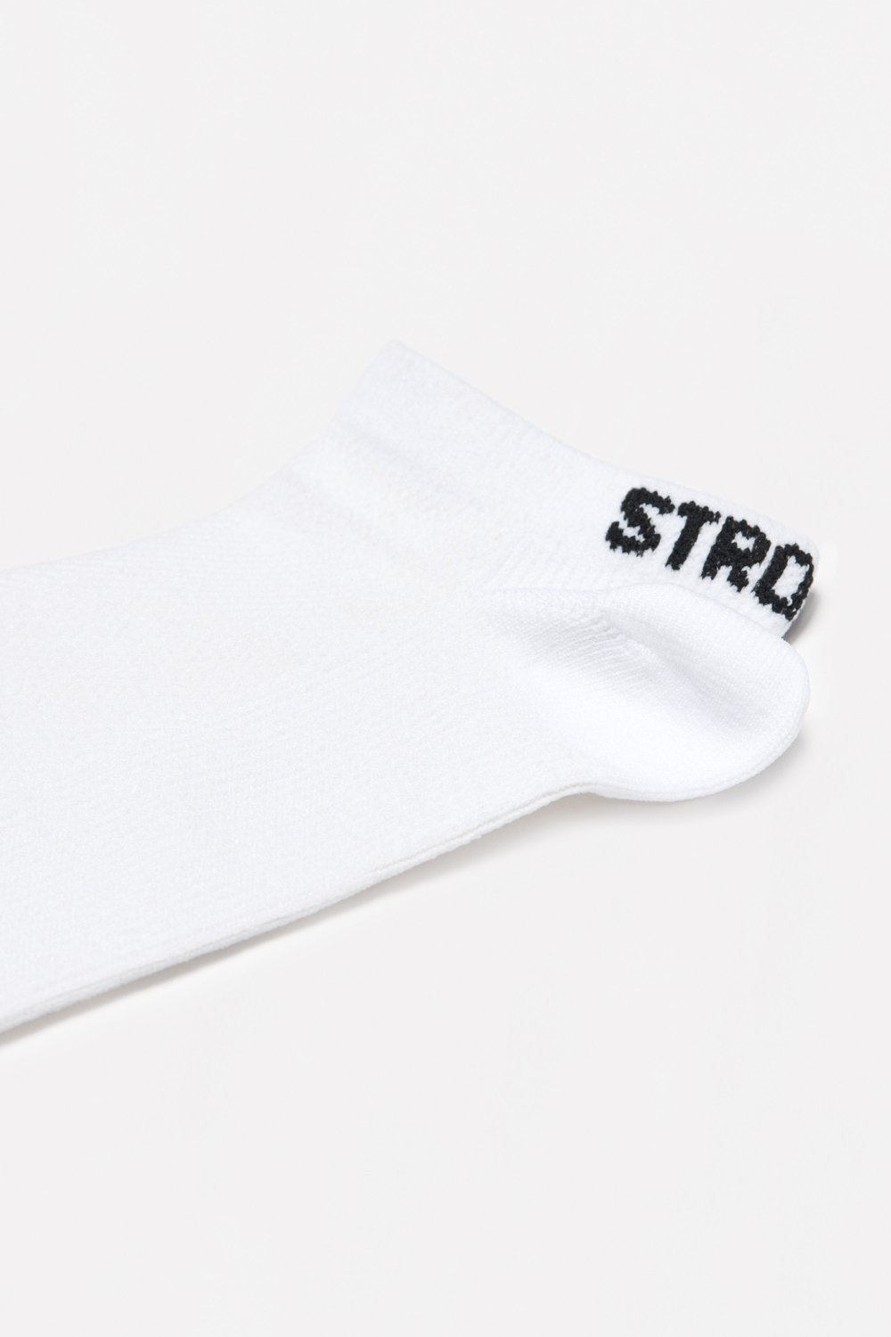 Close-up of the white Sporty Socks from stronger, showing the knitted ankle design and logotype at the back.