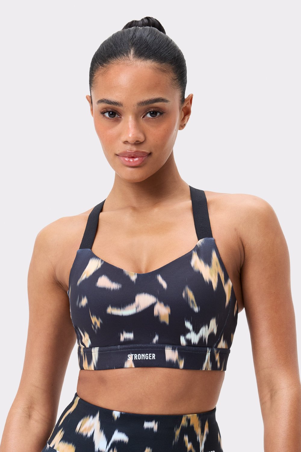 Power Sports Bra in Savannah Print from Stronger, featuring a dark abstract pattern and branded elastic straps.
