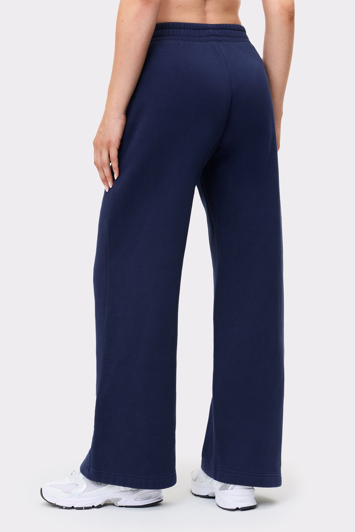 Rückansicht eines Models in den dunkelblauen Relaxed Wide Sweatpants von Stronger mit Oversize-Passform und geradem Bein.