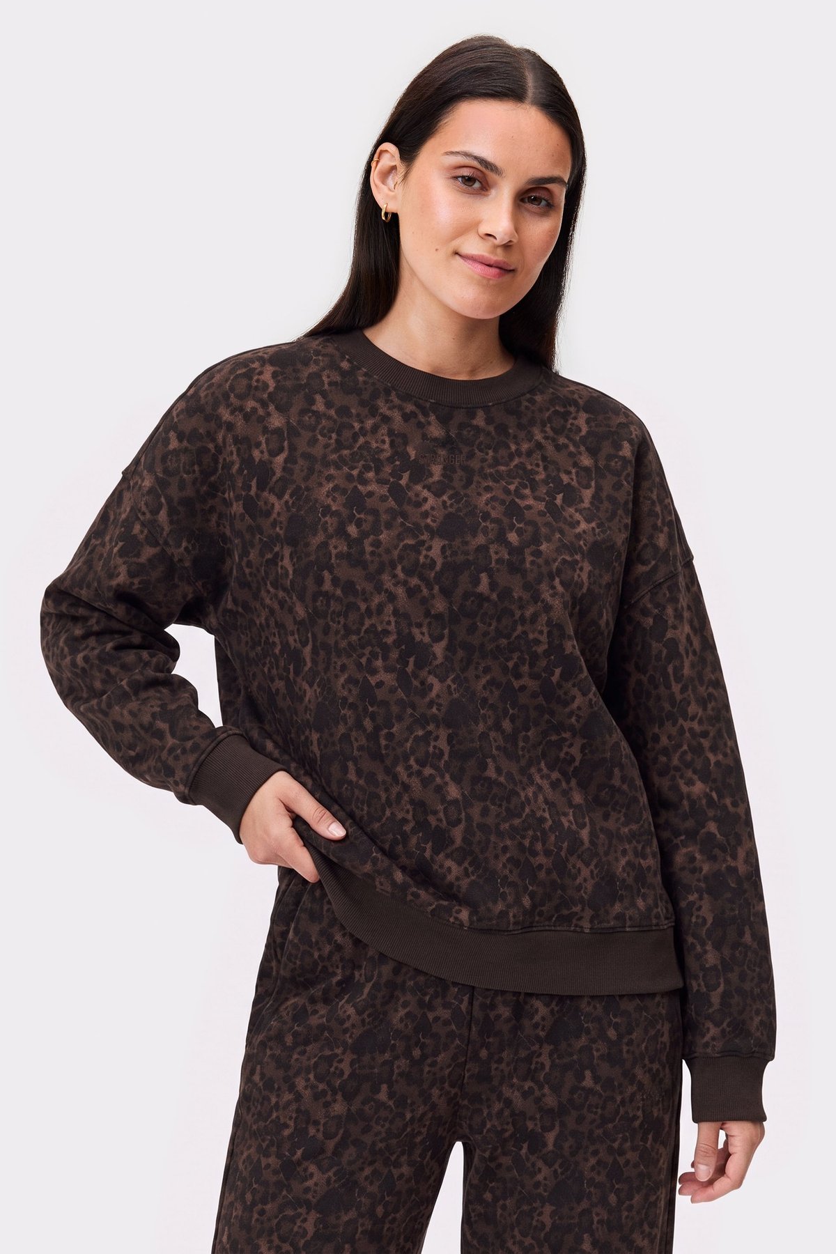 Model wearing the cozy Relaxed Sweatshirt in dark leopard print from stronger, showing an oversized fit and ribbed cuffs.