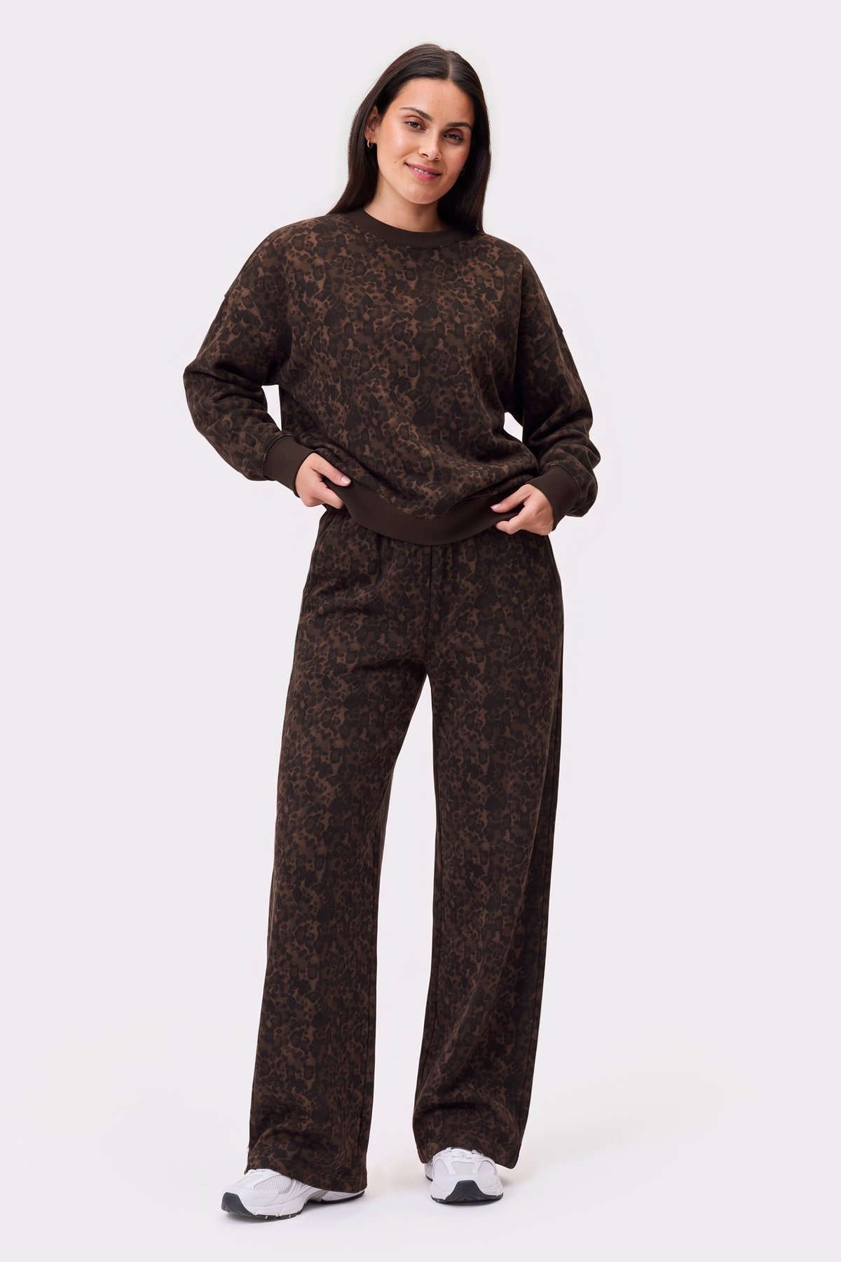 Model wearing the relaxed sweatshirt and matching sweatpants in dark leopard print from stronger, showing an oversized fit.