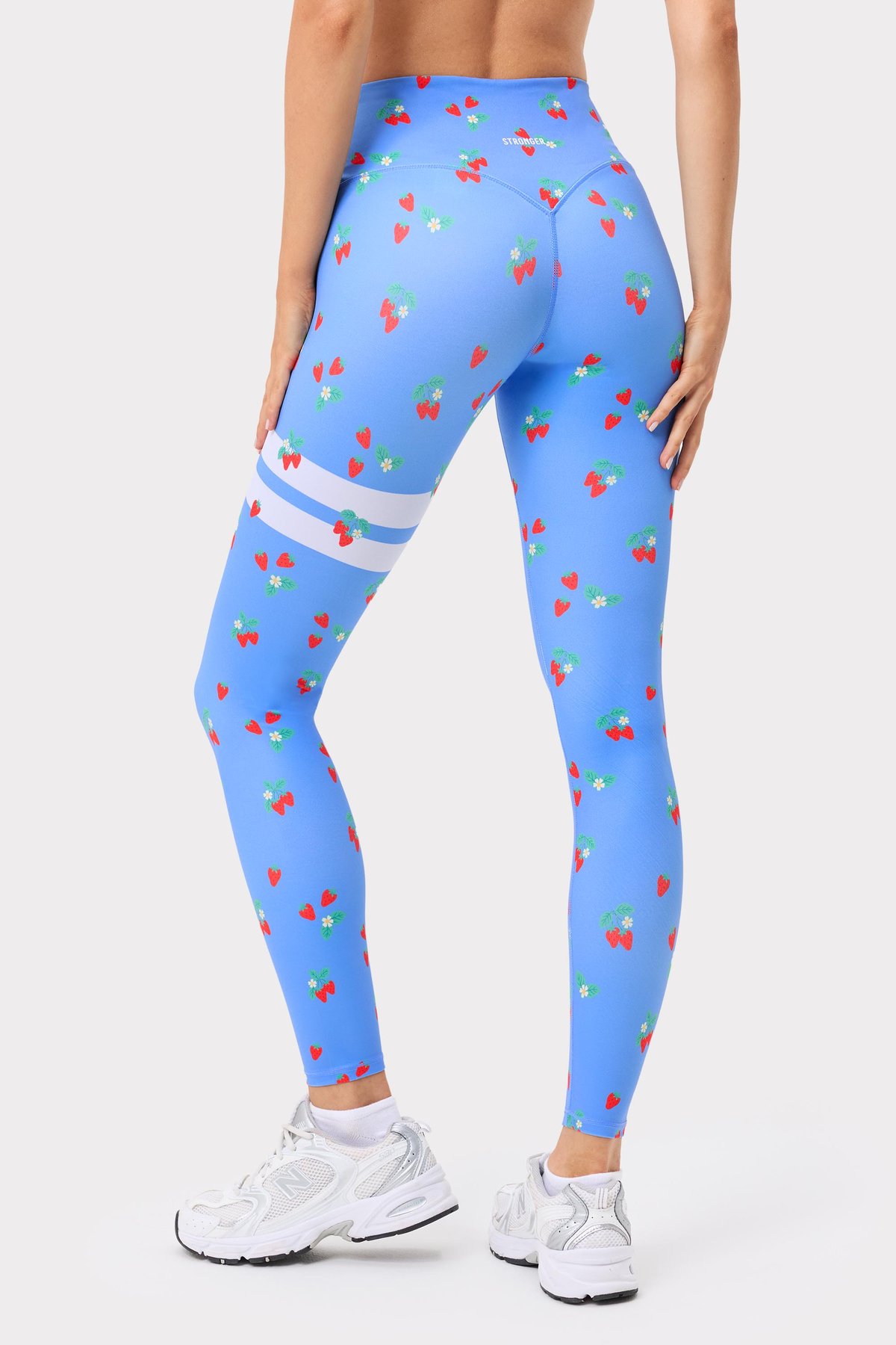Ljusblå The Printed One Tights från Stronger med jordgubbstryck och vita Signature Lines på låret.