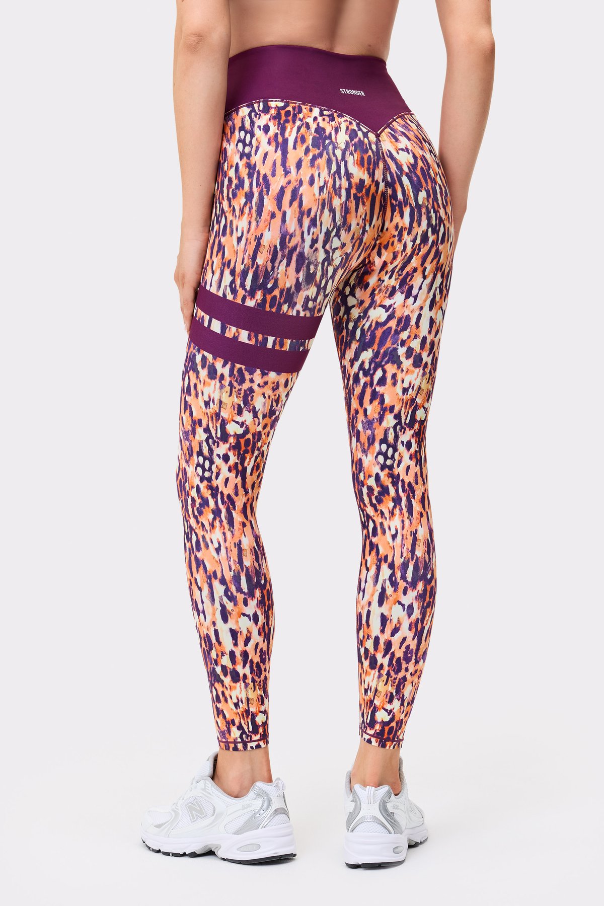 Back view of a person wearing Stronger The Signature One Leggings in Malibu Milk Print with signature stripes.