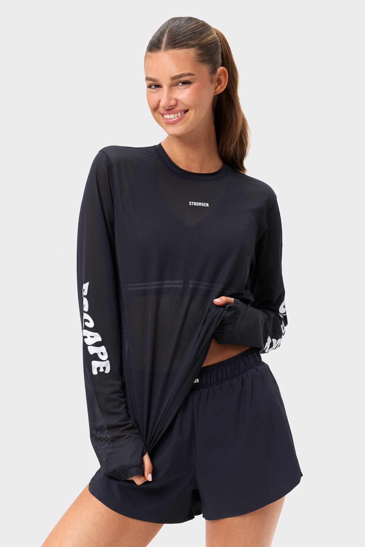 Black Mesh Running Long Sleeve by Stronger, featuring breathable mesh, thumbholes, and a loose fit for intense training.