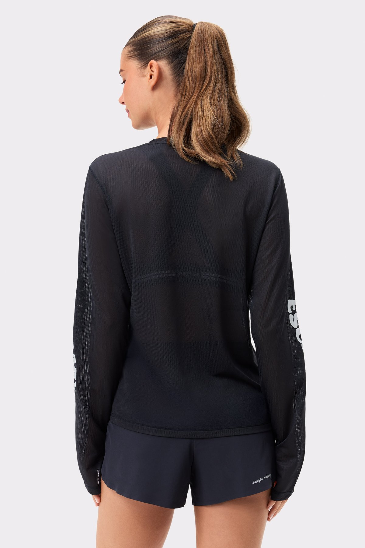 Back view of Stronger's black Mesh Running Long Sleeve, showcasing the breathable thin mesh and reflective back details.