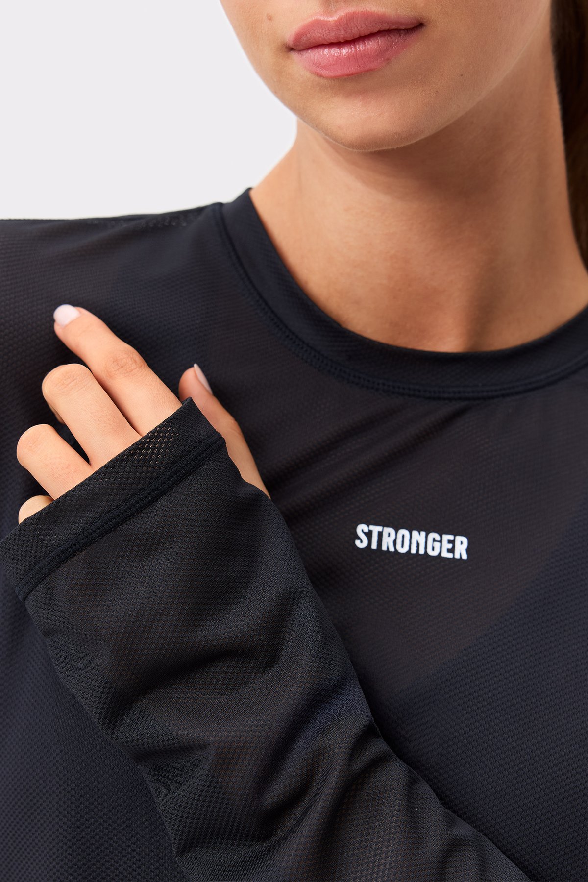 Close-up of the black Mesh Running Long Sleeve by Stronger, highlighting the breathable mesh fabric and thumbholes.