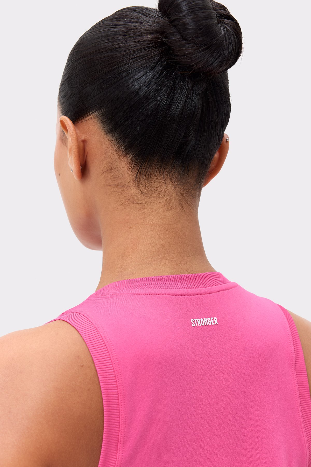 Close-up of the back of Stronger's dark pink Relaxed Tank, highlighting the centered logo and ribbed trim.