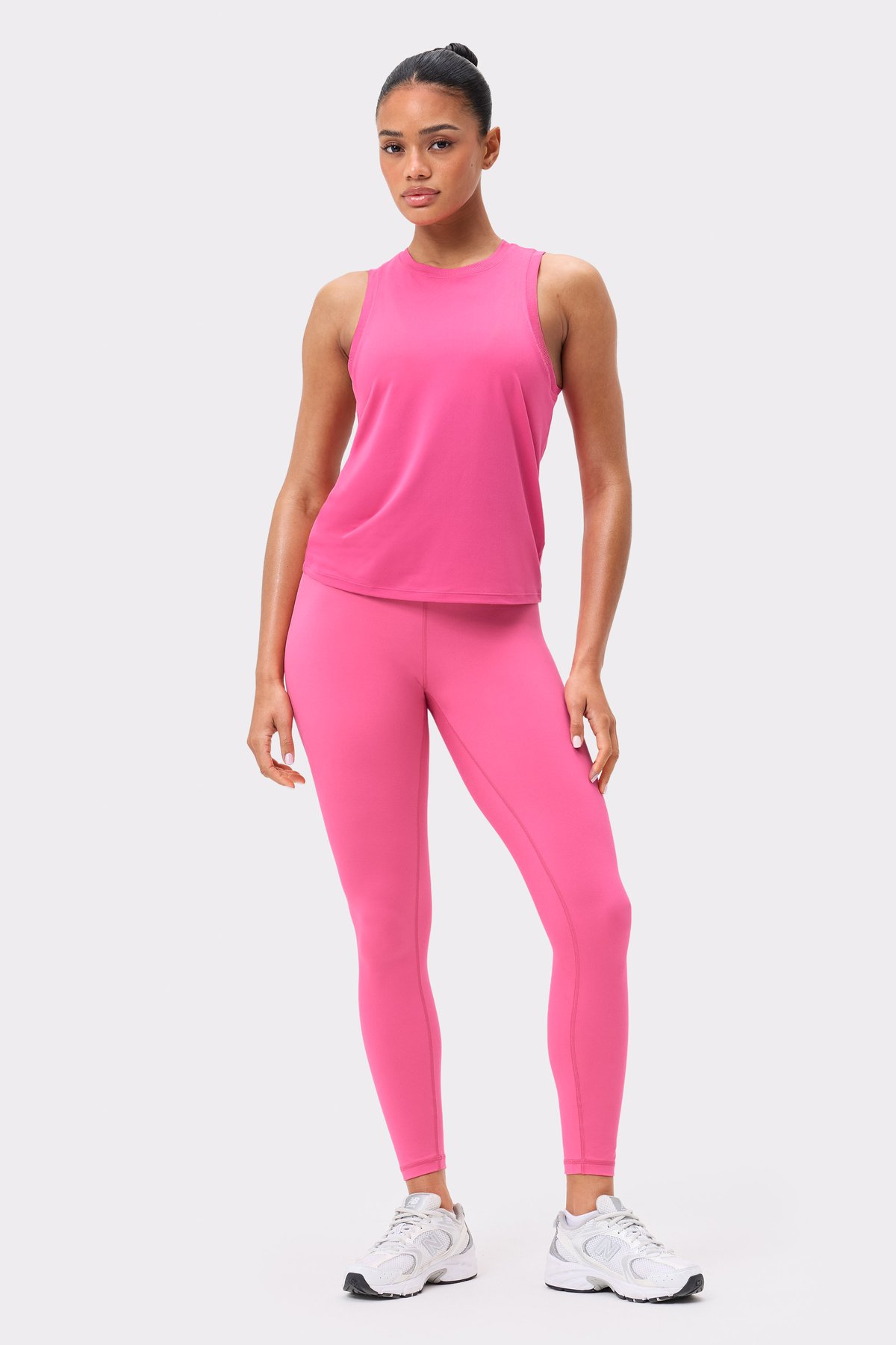 Front view of the dark pink Stronger Relaxed Tank, a breathable sleeveless top paired with matching leggings.