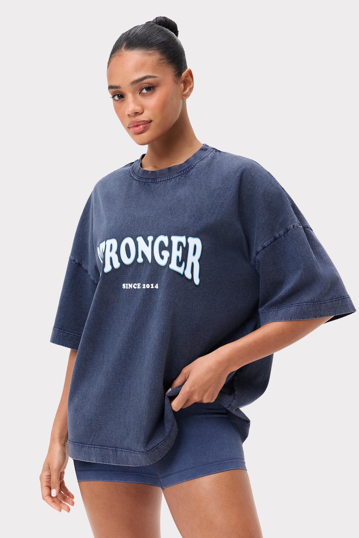 Model in het washed out Navy Blazer Oversized Crew T-shirt van Stronger met een geprint logo op de borst.