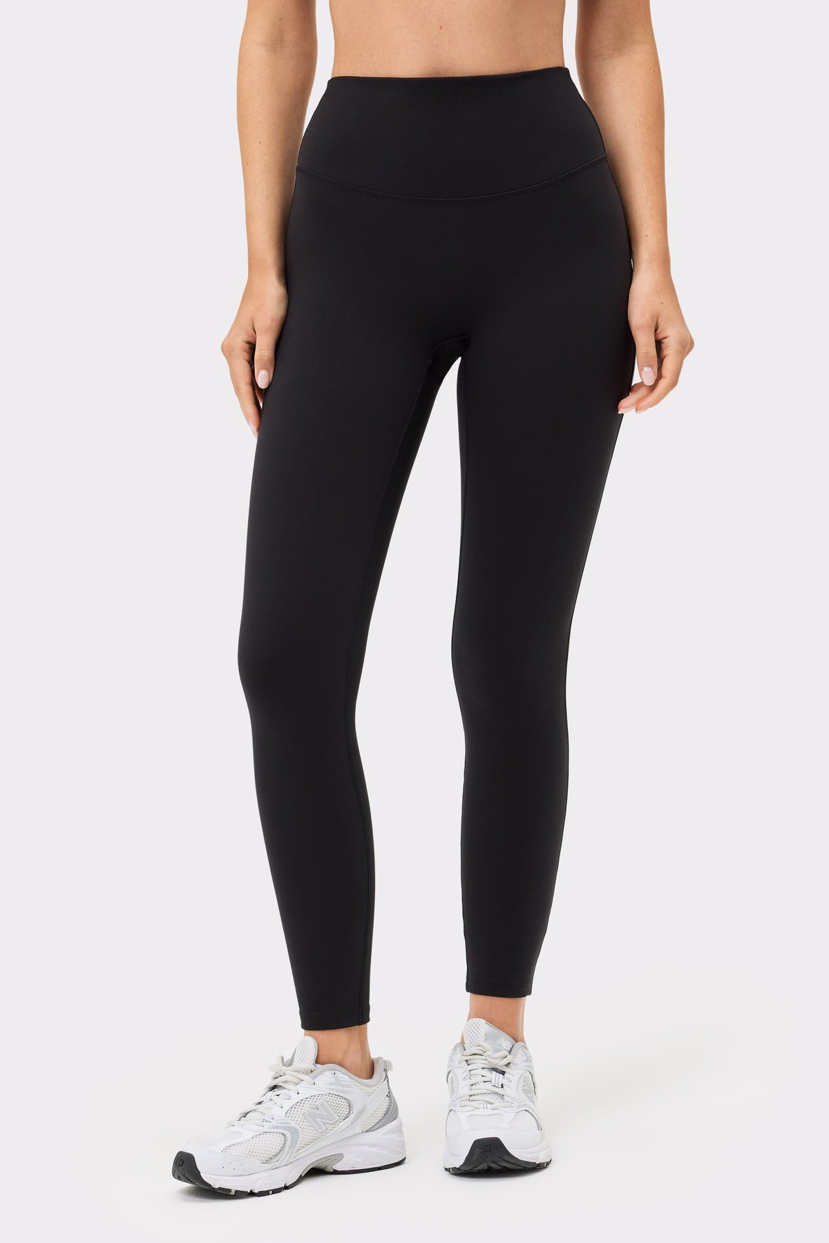 Close-up of a model wearing the high-waisted Soft Leggings in black from Stronger, showing the smooth, seamless design.
