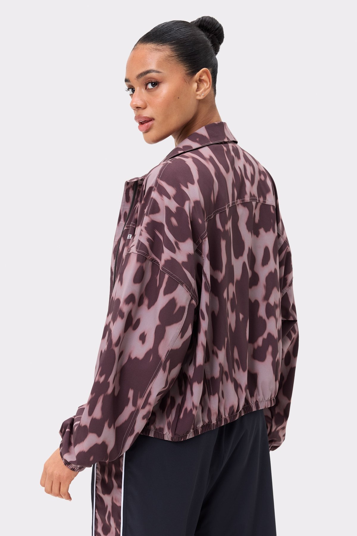 Zijaanzicht van de Breezy Woven Jacket van Stronger in Leo Rush-print, met een losse pasvorm en geweven stof met patroon.