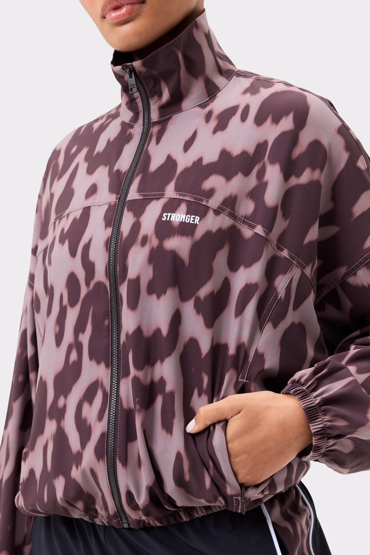 Close-up van de Stronger Breezy Woven Jacket in Leo Rush print, met een ritssluiting en stof met luipaardprint.