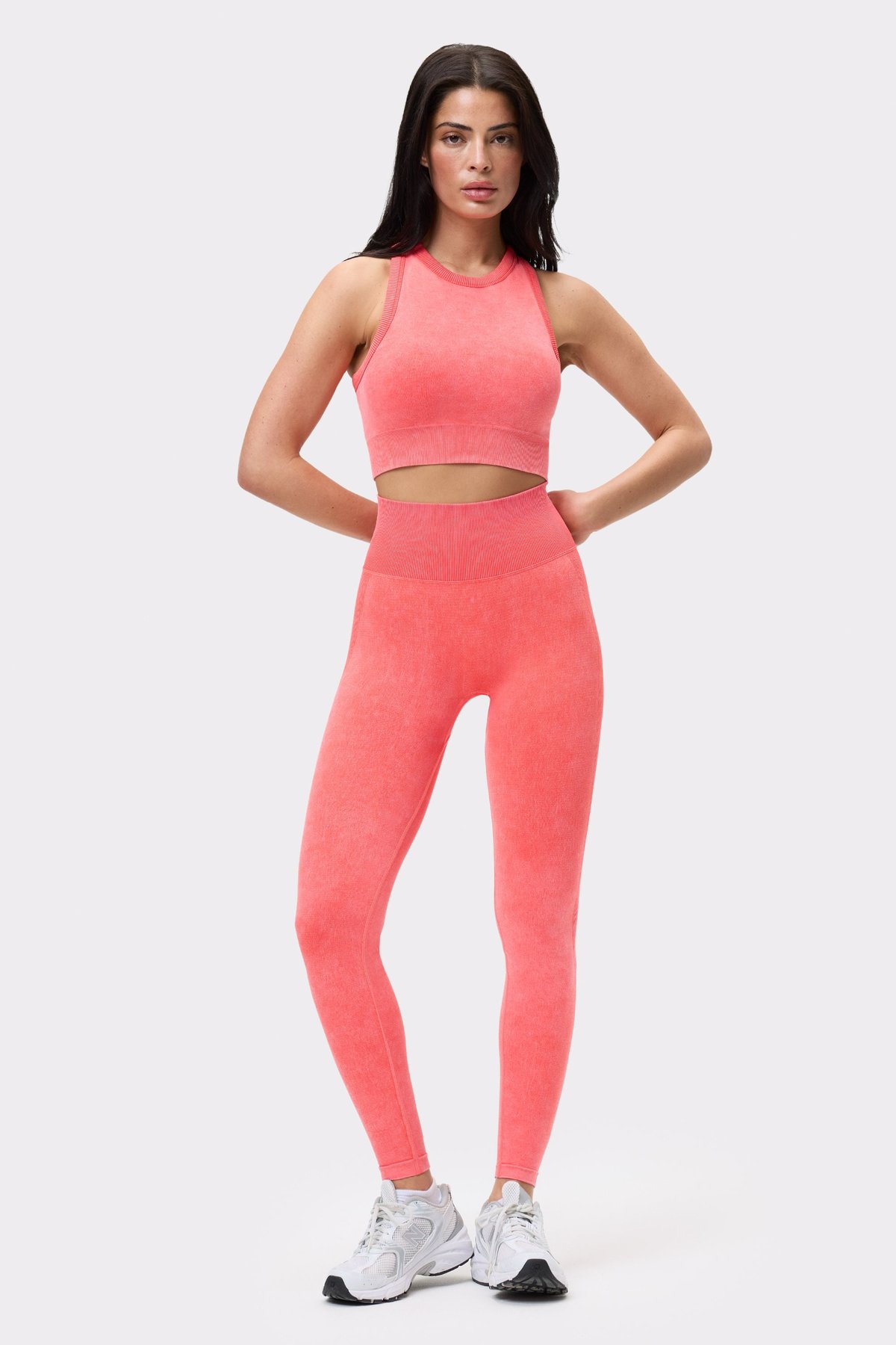 Vorderansicht eines Models im Washed seamless high neck bra Poppy Red und passenden Leggings mit Washed-Out-Look.
